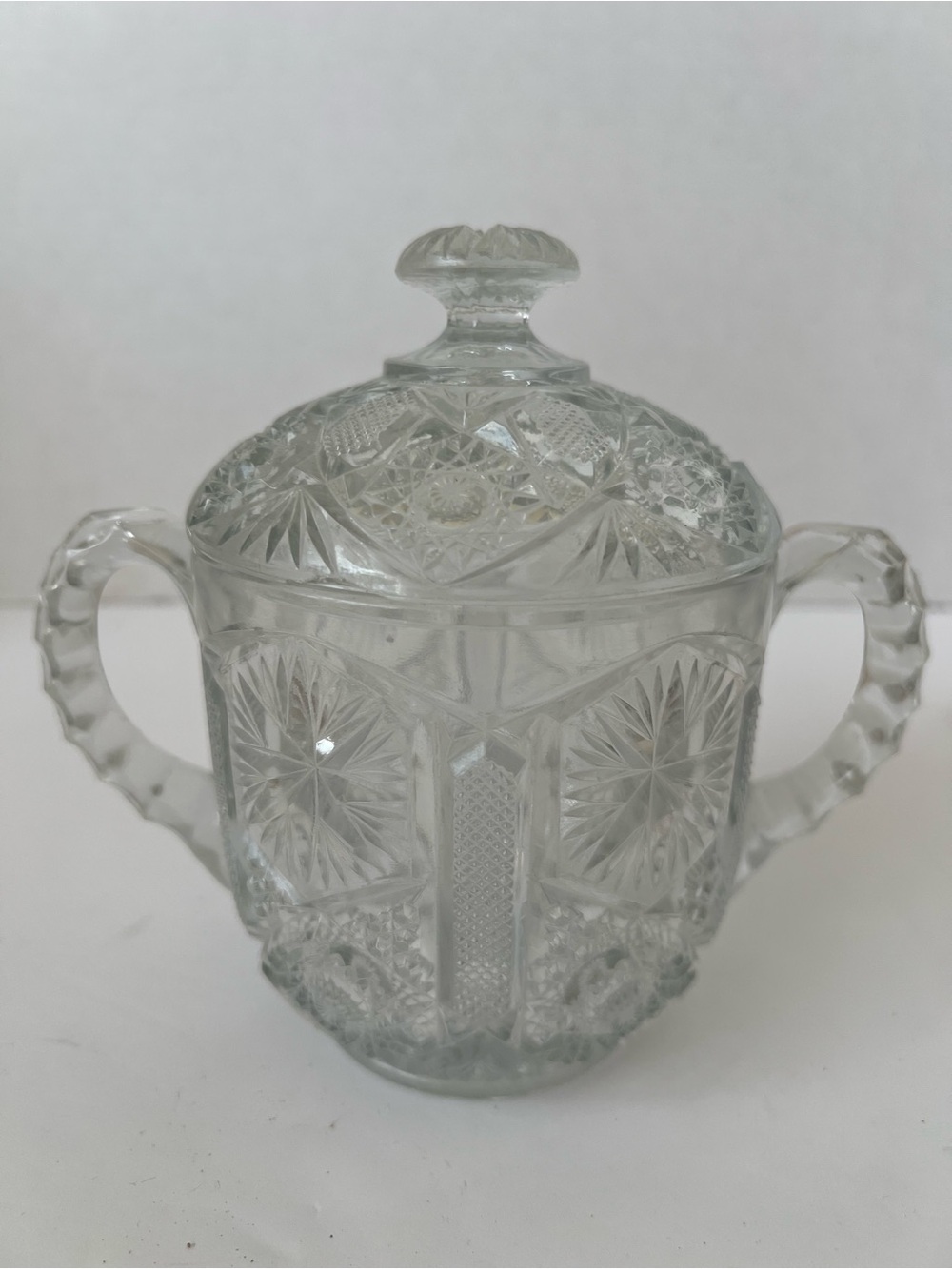 This is a vintage clear pressed-glass covered sugar bowl with 2 handles & lid